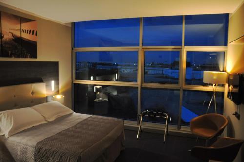 多索博诺维罗纳机场星级酒店的一间卧室设有一张床和一个大窗户