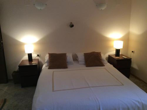 Razvalini BalchikioyVilla Tunley的一间卧室配有一张带两盏灯的大型白色床。