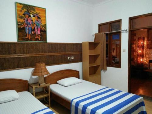 庞岸达兰迷你蒂加民宿的一间设有两张床和一盏灯的房间