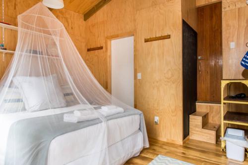 棕榈滩棕榈滩木屋的一间卧室配有一张带蚊帐的床