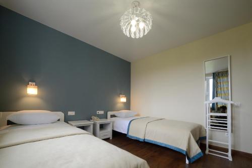 克麦罗沃Hotel Evraziya的一间卧室配有两张床和吊灯。
