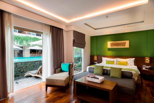 塞米亚克d'primahotel Petitenget Seminyak 2的一间卧室设有一张床和绿色的墙壁