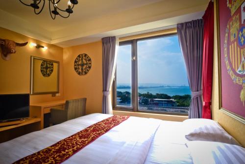 淡水和昌商旅淡水馆的酒店客房设有一张床和一个大窗户