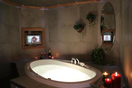 沃卡蒂Vuokatin Aateli Villa Ruhtinatar的一间带蜡烛浴缸的浴室和一台电视