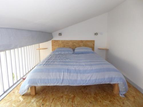 Apremont-la-ForêtDans un jardin的一间卧室配有一张蓝色和白色条纹的床