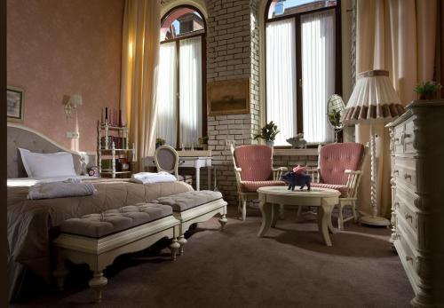 哈尔科夫19酒店的一间卧室配有一张床、两把椅子和一张桌子