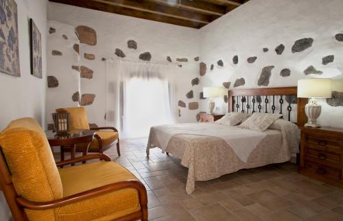 蒂亚斯Caserío Leandro II的卧室配有床、椅子和窗户。