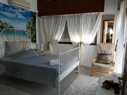 利马索尔Shared Top 1st floor villa的一间卧室设有一张床、一个窗口和一把椅子