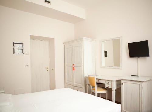 萨尼科赛比诺酒店的白色卧室配有书桌和床