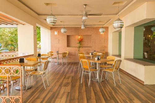比亚埃尔莫萨比亚埃尔莫萨米拉弗洛雷斯酒店的配有木桌和椅子的餐厅