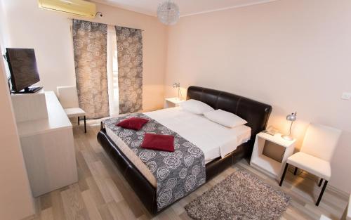 卡尼扎Hotel Aqua Panon的一间卧室配有一张带红色枕头的床