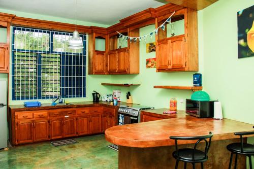 蒙特哥贝Sunshine Lodge: Your home away from home的厨房配有木制橱柜和木桌。