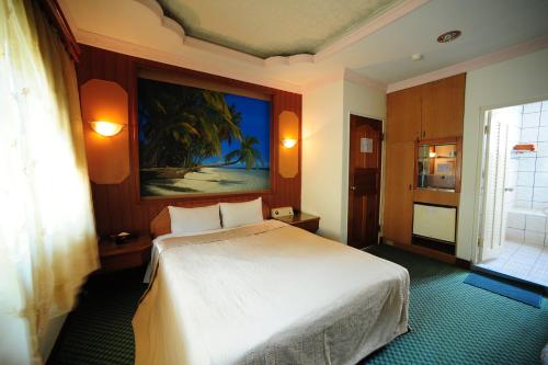 新竹金座渡假汽车旅馆的卧室配有一张白色大床