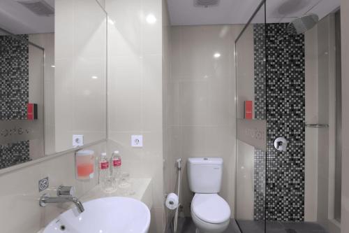 当格浪favehotel Bandara Tangerang的浴室配有卫生间、盥洗盆和淋浴。