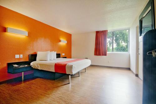 迈阿密迈阿密6号汽车旅馆的一间卧室配有一张带橙色墙壁的大床