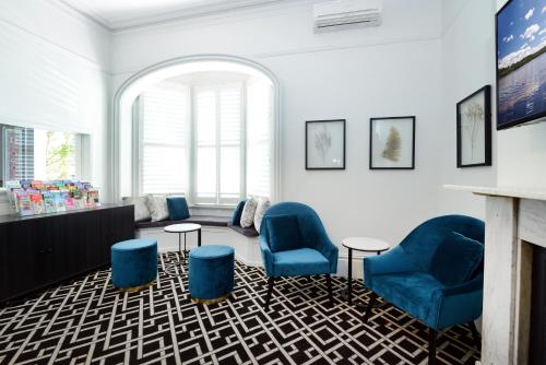 悉尼High Cross Randwick by Sydney Lodges的一间设有蓝色椅子和壁炉的等候室