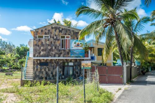 Rodrigues IslandMerlin Guest House的前面有棕榈树的建筑