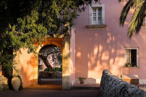 San Corrado di Fuori马赛利亚德格里乌里维酒店的粉红色建筑的入口,有拱门