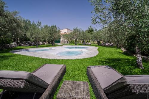 San Corrado di Fuori马赛利亚德格里乌里维酒店的一个带两把椅子的庭院内的游泳池