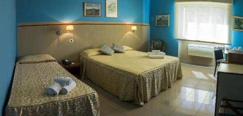 塔兰托广场酒店的酒店客房,设有两张床和蓝色的墙壁