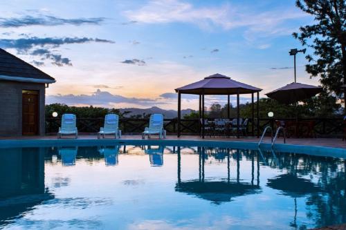 SaganaNokras Riverine Hotel & Spa的一个带椅子的游泳池和一个凉亭