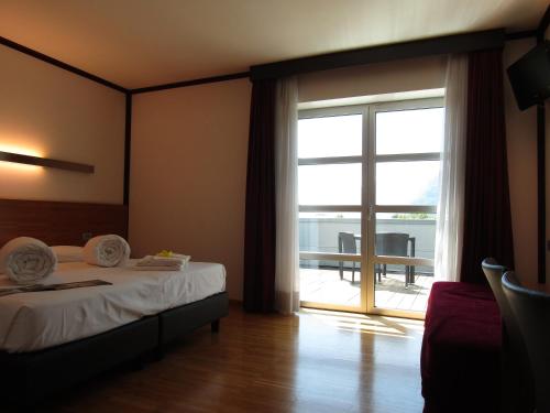 特伦托Al Marinaio Hotel Garni的一间卧室设有一张床和一个滑动玻璃门