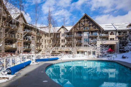 惠斯勒惠斯勒总理白杨酒店的一座大楼前的雪地中的一个度假游泳池
