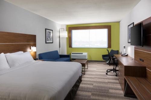 维塞利亚Holiday Inn Express Visalia-Sequoia Gateway Area, an IHG Hotel的酒店客房配有一张床、一张书桌和一台电视。