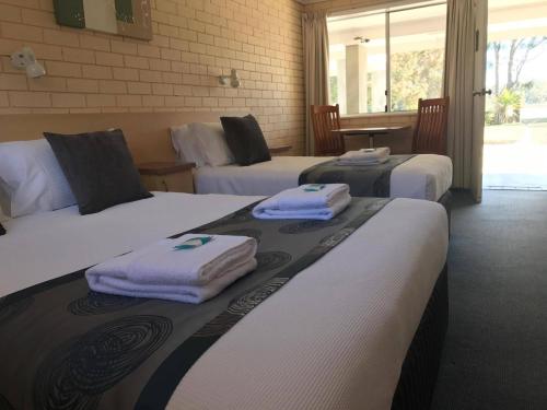 阿勒达拉The Edgewater at Burrill的酒店客房,配有三张床和毛巾