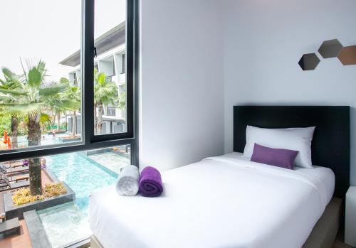 查汶Chaweng Villawee Hotel - SHA Plus的一间卧室设有一张床和一个大窗户