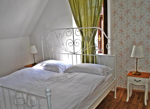 马里博尔Villa Winter Prestige Apartments的卧室内一张带金属床头板的白色床