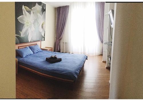 基辅Apartment on Lukyanovska的一间卧室配有一张带蓝色毯子的床和窗户。