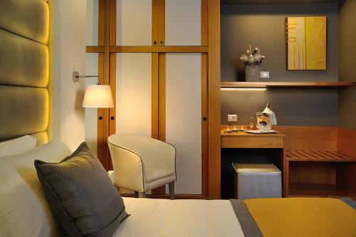 里乔内协和酒店的一间卧室配有一张床、一张桌子和一把椅子