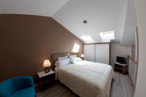 阿耶韦Hotel Asador O Callejón De Belchite的一间卧室配有一张床和一张蓝色椅子