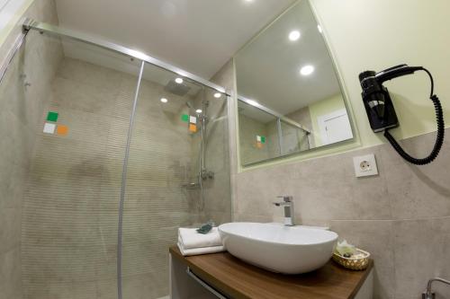 阿耶韦Hotel Asador O Callejón De Belchite的一间带水槽和玻璃淋浴的浴室