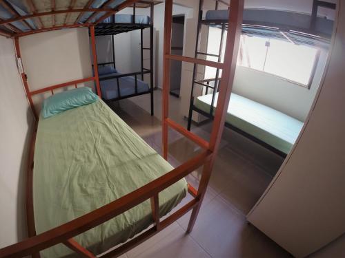 戈亚斯州上帕莱索Hostel Aventura的客房设有三张双层床和一扇窗户。