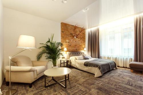 维尔纽斯Old Town Trio Apartments的一间卧室配有一张床、一张沙发和一把椅子