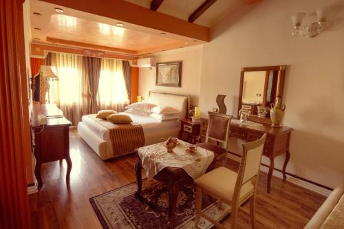 地拉那Hotel Villa Fernando Tirana的一间卧室配有一张床、一张桌子和一张书桌