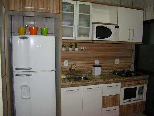 伊塔佩马Apartamento 3 quartos的厨房配有白色冰箱和微波炉