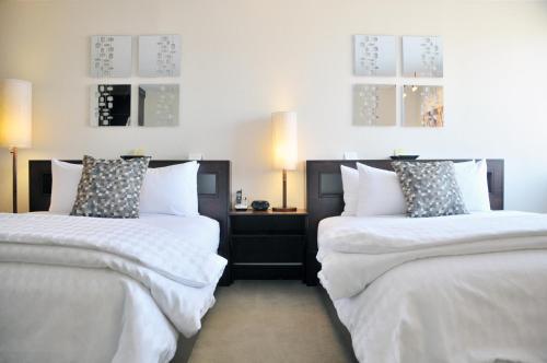 皮奥里亚马克吐温酒店的两张带白色床单和枕头的床。