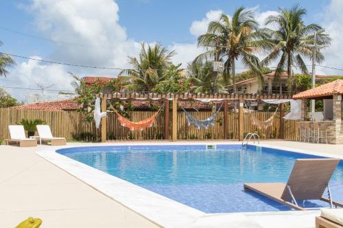 马塞约Wave Suítes Hotel & Lounge bar的后院的游泳池,带有木栅栏