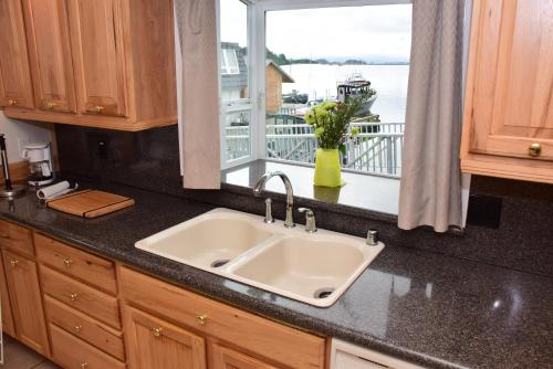 锡特卡Longliner Lodge and Suites的带水槽的厨房台面和窗户