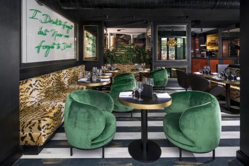 苏黎世中央广场酒店的一间餐厅,房间内设有绿色的椅子和桌子