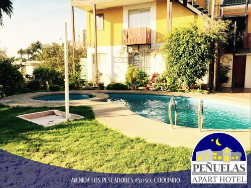 科金博Apart Hotel Penuelas的一座游泳池,位于一座建筑旁的院子内