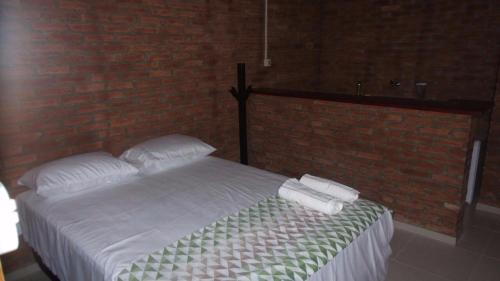 乌巴雅拉Pousada Sao Lourenco的一间卧室配有一张床,上面有两条毛巾