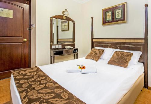 新加坡Hotel 81 Chinatown的一间卧室配有一张带镜子的大床