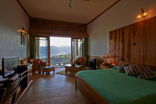 西隆Ri Kynjai Serenity by The Lake的一间卧室设有一张绿色的床和一个大窗户