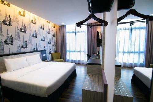 怡保因陀罗酒店 - 精品套房的配有一张床和一张书桌的酒店客房