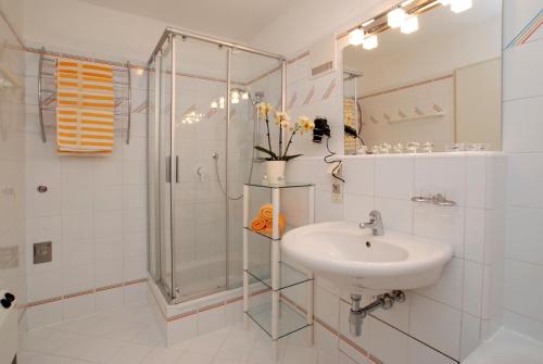 帕斯格许特路旁鲁斯巴赫Dachstein West Hotel GmbH-Kirchenwirt Russbach的带淋浴和盥洗盆的白色浴室