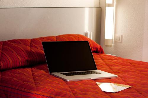 维耶尔宗普瑞米尔维耶宗经典酒店的床上的笔记本电脑
